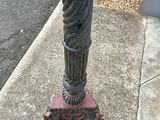 a bird bath sitting on a pedestal on the sidewalk