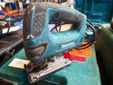 a corded jig saw sitting on top of a green box