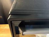 a black microwave oven sitting on top of a wooden table