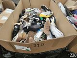 many pairs of shoes in a cardboard box on the ground