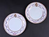 deux assiettes blanches ornées de bordures dorées et d'un motif violet et blanc
