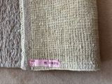 two pieces of fabric with a pink label on them