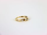 a close up of a gold ring with two diamonds on it