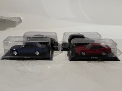 trois petites voitures exposées dans une vitrine