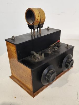 une petite boîte en bois surmontée d'un tuyau