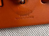 a close up of a brown leather bag with a metal handle