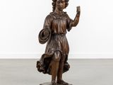 an antique bronze statue of a woman holding a basket