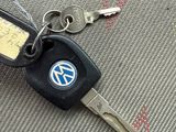 a keychain with a volkswagen logo on it sitting on a seat