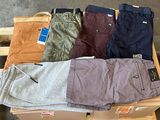 plusieurs paires de pantalons pour homme posées sur une caisse en bois