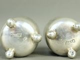 pair of silver plated salt and pepper shakers on grey background