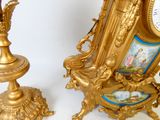 une horloge en or posée à côté d'un fauteuil doré