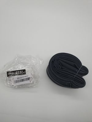 un cordon noir et un sac en plastique posés sur une surface blanche