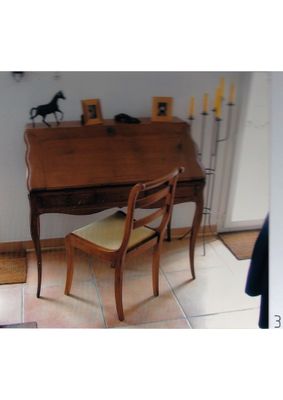 a small desk with a chair in the corner of the room