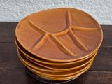 several brown plates stacked on top of each other on a wooden table