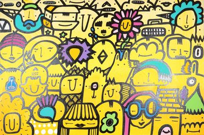 une peinture représentant un groupe de personnes sur un mur jaune
