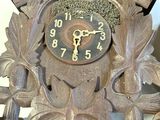 a wooden clock with a bird on the top of it