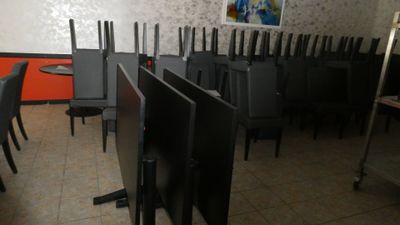 tables and chairs in a room with orange walls and a painting on the wall