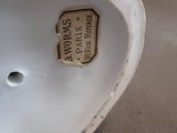 a white porcelain vase with a tag on it