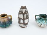 three different vases sitting next to each other on a white surface