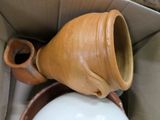 a brown vase sitting inside of a box with a white ball