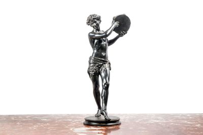 une statue représentant une femme tenant un éventail, posée sur une table