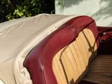 a red and white car with a tan seat cover on it