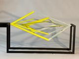 une sculpture en verre d'où sortent des bâtonnets jaunes