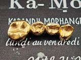 trois pépites d'or posées sur un livre noir