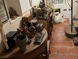 un homme debout dans une pièce où il y a beaucoup d'objets sur la table