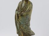 une statue en bronze d'une femme assise sur un rocher