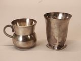 two silver cups sitting next to each other on a table