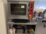 un micro-ondes argenté posé sur un support métallique dans une cuisine