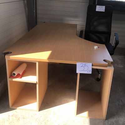 un bureau en bois avec une chaise noire dans un coin