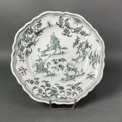 une image représentant une assiette verte et blanche ornée d'un oiseau et de fleurs