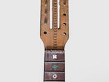 an old wooden guitar neck with a number of buttons on it