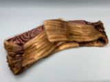 une image représentant une paire de gants garnis de fourrure posés sur une surface blanche