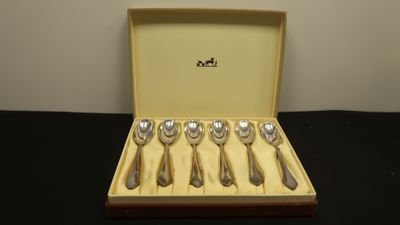 six spoons in a box on a table