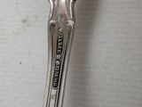 a silver spoon with a handle that has a spoon on it