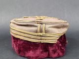 purple and beige velvet purse with gold zippers on a black surface
