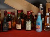 many bottles of alcohol sitting on a table next to a wooden box