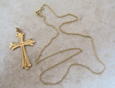 un gros plan d'une croix et d'une chaîne posées sur une table