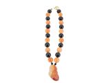 un gros plan sur un collier composé de perles orange et noires