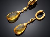 a pair of yellow crystal earrings on a black background