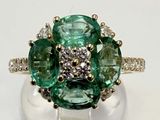 an image of a green and white diamond ring on top of a white surface