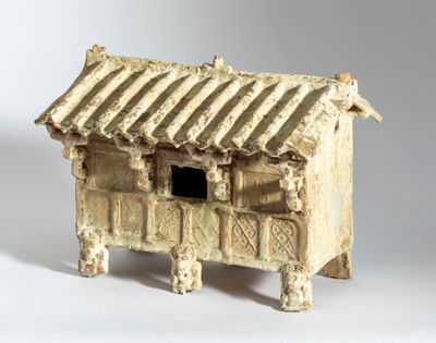 un petit bâtiment en argile posé sur une surface blanche