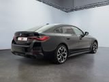 the rear end of a gray bmw car in a showroom