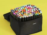 un sac noir rempli de feutres et de stylos sur fond jaune