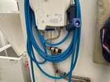 un tuyau bleu fixé à un mur blanc, à côté d'un autre tuyau bleu