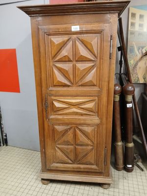 a tall wooden cabinet with a door on top of it