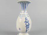 a blue and white vase sitting on a gray surface
